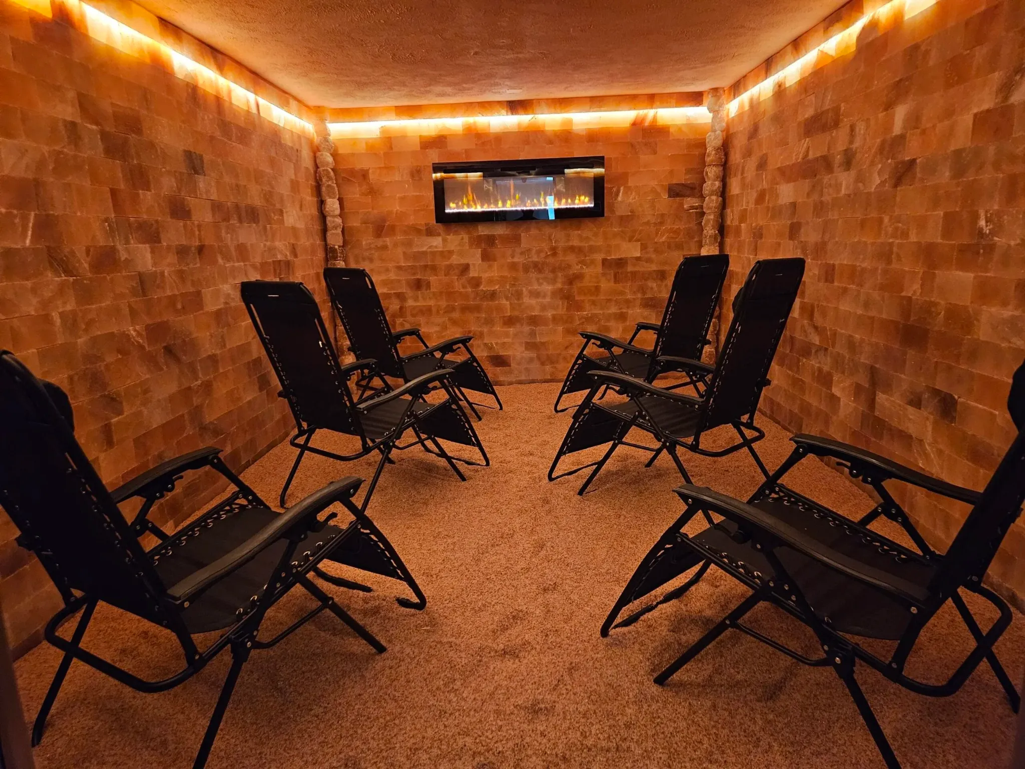 Himalayan salt cave with illuminated salt brick walls and reclining chairs